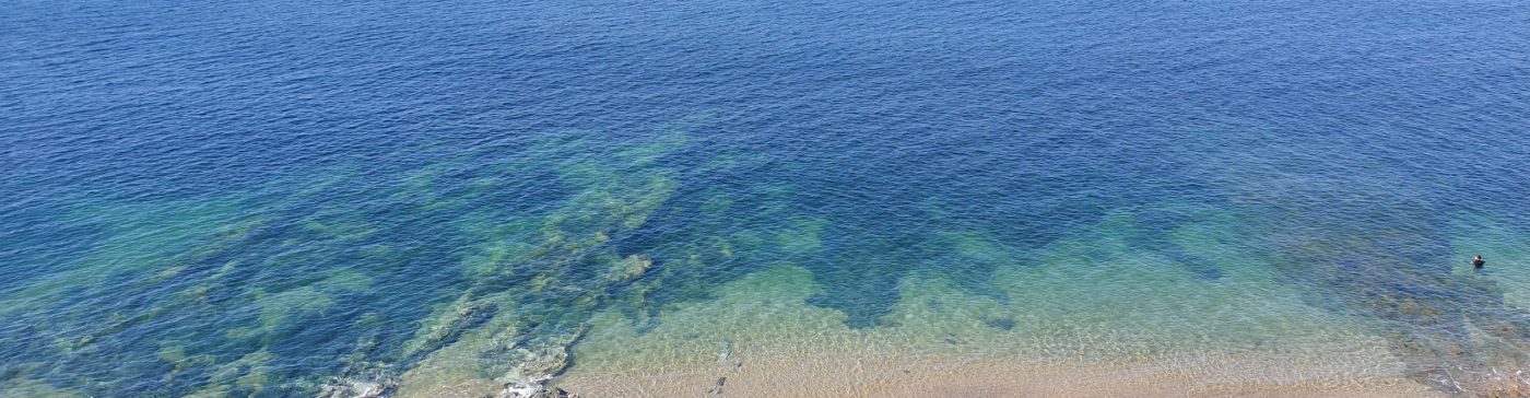 Looking down on sand and clear blue sea